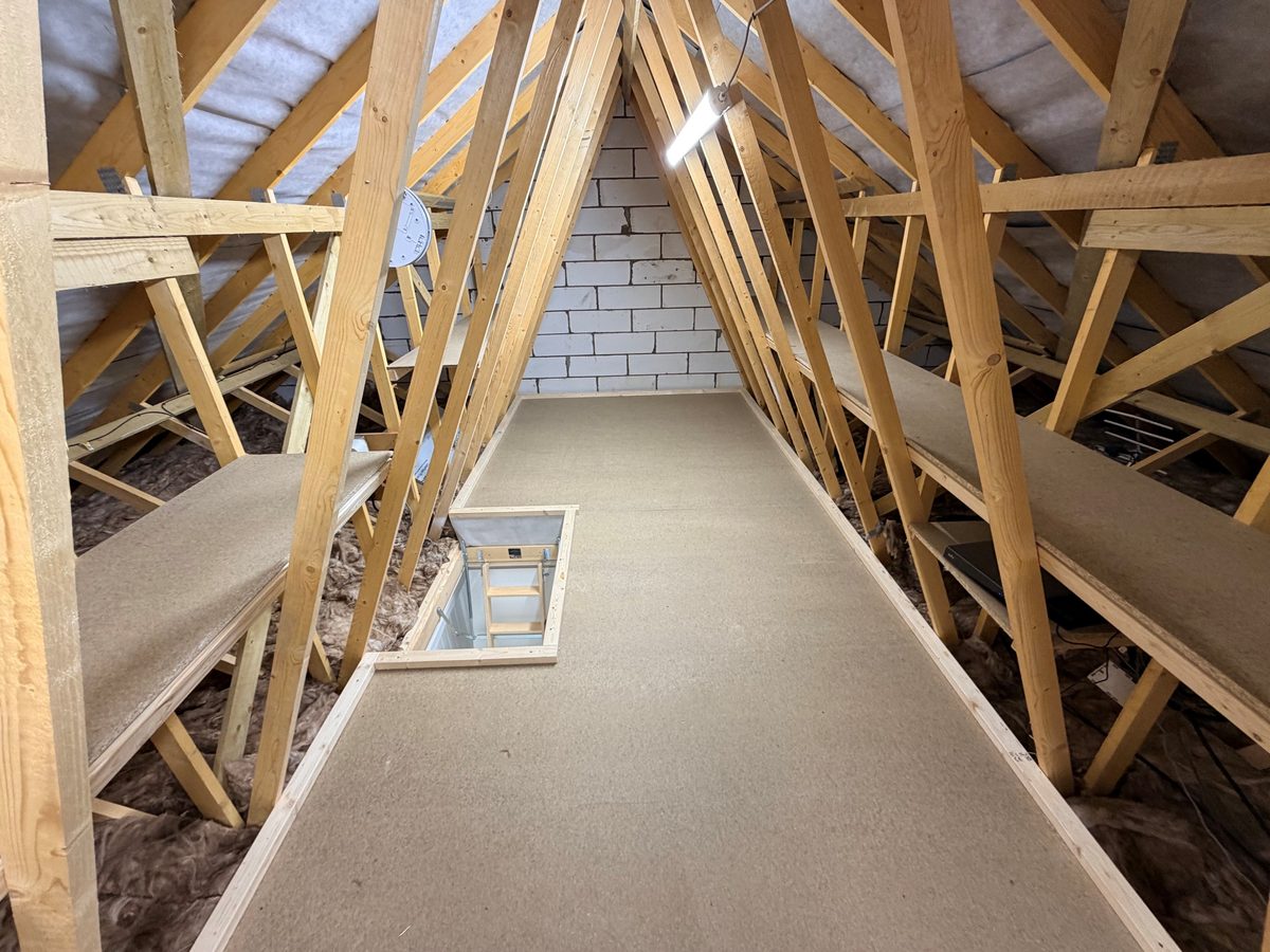 A loft boarded by Earsham Lofts using a raised floor system, with the insulation left at full depth beneath the boards