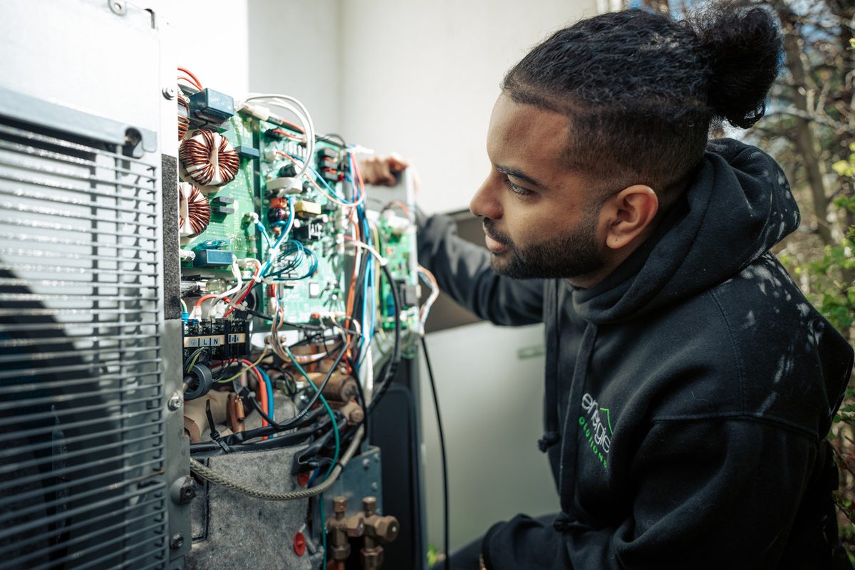 An Energie Solutions engineer diagnosing a fault on the control board of a heat pump