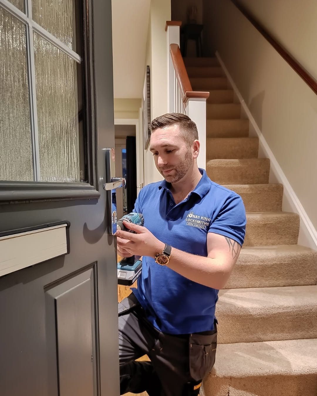 Jonas King fitting a new lock to a customer's front door