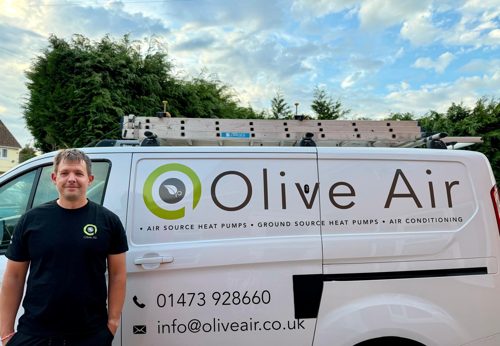 Tom from Olive Air Ltd standing beside the branded Olive Air van